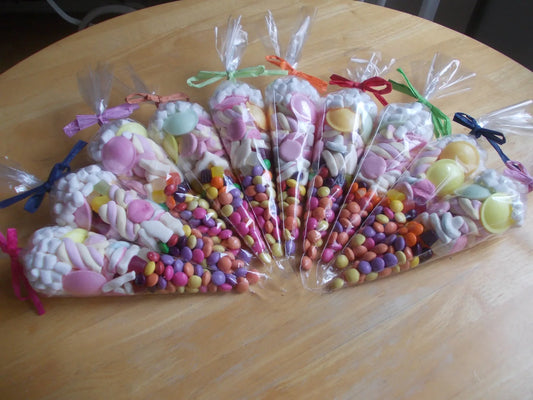 Mixed coloured sweet cones party favours with a mix of sweets chocolate and marshmallows 