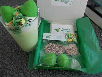 Lovely green box with everything you need to make a Dinosaur  themed milkshake including dinosaur sprinkles large green marshmallows milkshake mix and large chocolate butons   